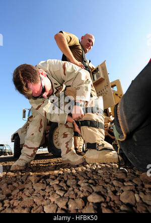 110402-F-XM360-020 CAMP LEMONNIER, Gibuti (2 aprile 2011) Il tenente j.g. Giovanni Mauro, team leader per l'eliminazione degli ordigni esplosivi unità mobile (EODMU) 11, regola l'eliminazione della bomba tuta indossati dai Sottufficiali di terza classe Ryan Donofrio prima dell'EOD Memorial 5K l'esecuzione. Il team EOD organizzato la corsa per aumentare la consapevolezza del sacrificio di EOD tecnici in tutto il mondo e di portare l'attenzione all'EOD Memorial Foundation, una organizzazione non-profit istituita a nome di feriti o defunto EOD tecnici e le loro famiglie. (U.S. Air Force foto di Master Sgt. Alba M. Prezzo/rilasciato) - UFFICIALE DEGLI STATI UNITI Navy Foto Stock