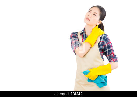 Stanco attraente giovane donna al collo e alla spalla dolorosa in giallo i guanti e il grembiule permanente e la scatola di contenimento con detergente isolato su sfondo bianco Foto Stock