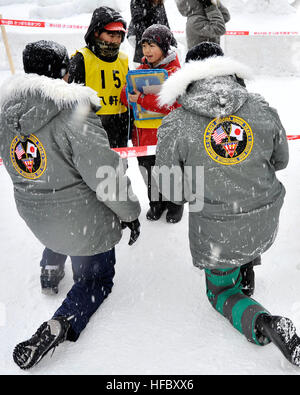 Chief Builder Billy Harger, sinistra, che ha originariamente saluta da Pearl City, Hawaii e Mineman marinaio Andrew Handley, originariamente da Stroud, Okla., interagiscono con la scuola i bambini durante il sessantacinquesimo annuale di Sapporo Snow Festival, Febbraio 7, 2014. Entrambi sono membri del 2014 Navy Misawa combatté Team di neve, che attualmente è a Sapporo, Giappone prendendo parte nella città del festival annuale del. Il team scolpito un pupazzo di neve, 3-D versione degli STATI UNITI Navy Seabee 'combattimenti Bee logo". Questo è il trentunesimo anno che Naval Air Facility Misawa combatté e il suo inquilino comandi hanno inviato una delegazione di marinai a Sapporo per creare una scul Foto Stock