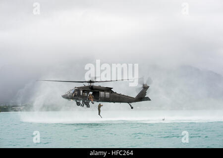 Un sito ufficiale della Royal Navy l'eliminazione degli ordigni esplosivi (EOD) tecnico, assegnato al gioco Australia Diving Team uno, salta fuori da un U.S. Esercito UH-60L Black Hawk elicottero, assegnati al 2° Stormo, 6° reggimento di cavalleria xxv combattere la Brigata Aerea, XXV divisione di fanteria, come parte di una multinazionale elicottero-inserimento durante il processo di familiarizzazione Rim del Pacifico (RIMPAC) Esercizio 2014. Ventidue nazioni, 49 navi e sei sommergibili, più di 200 aerei e 25.000 personale partecipano RIMPAC esercizio dal 26 giugno al 1 agosto, in e intorno alle Isole Hawaii e Californi meridionale Foto Stock