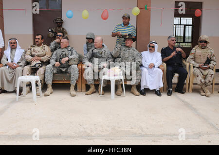 Ahmed Kurdin Nasahr, membro dell'Rashaad Sub-distrcit consiglio, un funzionario iracheno, U.S. Col. Larry Swift, commander, pronto prima, 1° Brigata Team di combattimento, 1° Divisione Corazzate, Briga. Gen. Patrick J. Donahue, II, vice comandante generale (manovra) terza divisione di fanteria, Lt. Col. Brian McHugh, comandante dello squadrone, 6° Stormo, 1° Cavalleria, 1° Brigata Team di combattimento, 1° Divisione Corazzate, Ahmed Omaeer, muktar, di Nasaria, Iraq e il cap. Ahmad Ghaffur Qassin, chief, Rashaad iracheno stazione di polizia, sedersi insieme per guardare la cerimonia del taglio del nastro per la scuola Nasaria Maggio 3, 2010. Stati Uniti Soldati fro Foto Stock