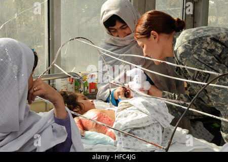 Marina degli Stati Uniti Petty Officer 1. classe Monica Nelson dà un coniglietto ripiene di un olocausto ragazza afghana in Indira Ghandi ospedale per bambini masterizzare Ward mentre il servizio internazionale membri anche assegnati alla forza internazionale di assistenza alla sicurezza sede passano fuori animali imbalsamati e matite colorate per i pazienti ustionati, nel centro di Kabul, Afghanistan, nov. 20. L'ospedale riceva 400 dollari al mese per eseguire tutto il luogo e i bambini masterizzare Ward è un regolare il destinatario di aiuti internazionali portate dai volontari di ISAF. Indira Gandhi ospedale per bambini masterizzare Ward 130214 Foto Stock