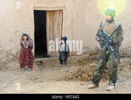 I bambini del villaggio emerge dalla loro casa per osservare l'attività di un soldato dal 8 Commando Kandak in Doan-e Ulya Village, Shahid-e distretto Hasas, provincia di Uruzgan, Afghanistan, Feb. 6. Il 8° Commando Kandak partner della coalizione con forze per le operazioni speciali per condurre operazioni in tutta Uruzgan e Zabul province. 8 Commando operazione Kandak 120206-N-MIA805-083 Foto Stock