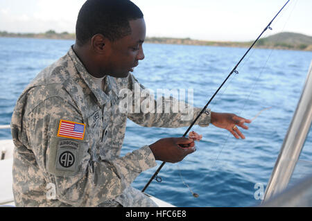 Spc. Howard Jones, un armorer per la 189Polizia Militare Company, mette un calamaro su un gancio durante un militare congiunta viaggio di pesca nella baia di Guantanamo, 8 luglio. Jones è una delle diverse truppe di stanza a Joint Task Force e la stazione navale di Guantanamo che si offrono volontari per insegnare nel benessere morale e la ricreazione sponsorizzato basic lezioni di pesca. Militare congiunta viaggio di pesca 110708-N-MN220-021 Foto Stock