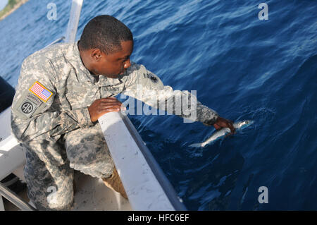 Spc. Howard Jones, un armorer per la 189Polizia Militare Company, rilascia un pesce di nuovo in acqua durante un militare congiunta viaggio di pesca nella baia di Guantanamo, 8 luglio. Jones è una delle diverse truppe di stanza a Joint Task Force e la stazione navale di Guantanamo che si offrono volontari per insegnare nel benessere morale e la ricreazione sponsorizzato basic lezioni di pesca. Militare congiunta viaggio di pesca 110708-N-MN220-172 Foto Stock