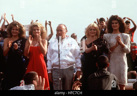 Intrattenitore Bob Hope esegue per i marinai a bordo della nave da guerra USS NEW JERSEY (BB-62) con guida da sinistra a destra: Miss U.S.A. Judy Hyek, Cathy Lee Crosby, Ann Jillian e BROOKE SHIELDS, durante una vigilia di Natale OSU show. Il NEW JERSEY è operativo al largo di Beirut, Libano. Julie Hayek OSU Tour Foto Stock