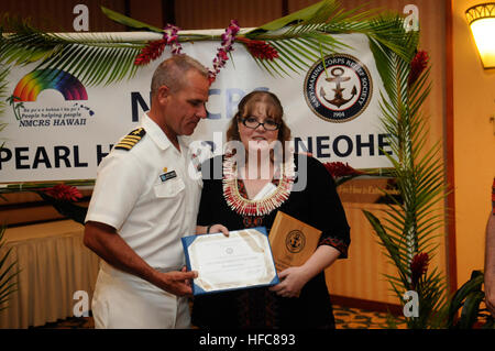 Il cap. Jeffrey James, comandante della base comune Harbor-Hickam Pearl presenta il 2012 volontario del premio di anno a Meredith Gaston durante un premio per il pranzo presso il Hale Koa Hotel Waikiki e sala da ballo, gen. 22. L'evento onora il personale e i volontari del NMCRS, nonché per premiare i volontari per il loro eccellente lavoro. (U.S. Foto di Marina di Massa lo specialista di comunicazione 2a classe Nardel Gervacio Gervacio/RILASCIATO) Kokua Awards 130122-N-ZK021-153 Foto Stock