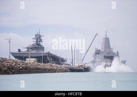 150828-N-TW634-033 Okinawa, in Giappone (Agosto 28, 2015) Una Landing Craft Air Cushion (LCAC), assegnato alla spiaggia navale unità (NBU) 7, offload 31 Marine Expeditionary Unit (MEU) attrezzatura dal pozzetto deck di trasporto anfibio dock nave USS Green Bay (LPD 20) come ella è ormeggiata pier accanto all'assalto anfibio nave USS Bonhomme Richard (LHD 6). Bonhomme Richard e Green Bay sono assegnati al Bonhomme Richard Expeditionary Strike gruppo e sono di pattuglia NEGLI STATI UNITI 7 flotta area di operazioni. (U.S. Foto di Marina di Massa lo specialista di comunicazione di terza classe Derek A. Harkins/RILASCIATO) LCAC 9 offl Foto Stock