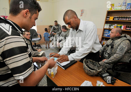 Stati Uniti Soldati di Charlie truppa, primo plotone, 1-150th corazzato squadrone di ricognizione, trentesimo Heavy Brigade Combat Team, 1a divisione di cavalleria da Bluefield, W.Va., condurre una riunione a Samir ambulatorio medico per discutere eventuali micro-sovvenzioni per un dentista di sedia operativa, maternità servizi per la gente del posto e accesso ad acqua potabile pulita per la clinica, in Radwaniyah, Baghdad, Iraq, Ottobre 3, 2009. Mentre nel corso della riunione, i membri dell'1-150th sono stati in grado di spendere tempo interagendo con gli enti locali di bambini iracheni e partecipare degli iracheni cibo presentato dalla Samir clinica medica personale. Micro-concessione discussioni Foto Stock