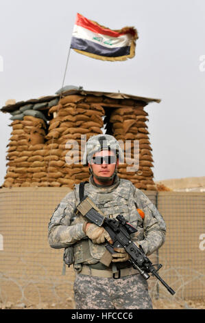 Un U.S. Soldato da Charlie truppa, primo plotone, 1-150th corazzato squadrone di ricognizione, trentesimo Heavy Brigade Combat Team, 1a divisione di cavalleria da Bluefield, W.Va., sorge da un checkpoint iracheno durante un incontro a Samir ambulatorio medico per discutere eventuali micro-sovvenzioni per un dentista di sedia operativa, maternità servizi per la gente del posto e accesso ad acqua potabile pulita per la clinica, in Radwaniyah, Baghdad, Iraq, Ottobre 3, 2009. Mentre nel corso della riunione, i membri dell'1-150th sono stati in grado di spendere tempo interagendo con gli enti locali di bambini iracheni e partecipare degli iracheni cibo presentato dalla Samir Clinica Medica s Foto Stock