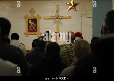 Padre Alex, un cappellano sloveno, offre un messaggio di americani e sloveni membri della coalizione durante una vigilia di Natale la Messa di mezzanotte in avanti nella posizione di base operativa della cappella di Farah, Dic 24. (U.S. Navy foto di tenente j.g. Matteo Stroup/RILASCIATO) messa di mezzanotte su FOB Farah 121224-N-LR347-297 Foto Stock