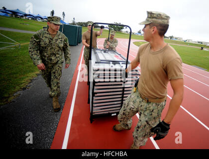 Seabees dalla base navale di Mobile Battaglione di costruzione 3 per completare l'impostazione tabelle prima il calcio di inizio del XIV annuale di Kadena Special Olympics. Volontari da Naval Mobile Battaglione di costruzione 3 sia aiutato a prepararsi per il xiv annuale di Kadena Special Olympics e applauditi atleti il giorno dell'evento. La Kso è stata istituita dal XVIII Wing Commander nel 1999 come una via per costruire relazioni con le comunità vicine e i rappresentanti locali del governo fornendo allo stesso tempo una significativa attività per le particolari esigenze di bambini e adulti. L'evento è cresciuto da circa 100 atleti di mor Foto Stock