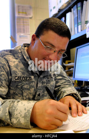 GUANTANAMO Bay a Cuba - Esercito Sgt. Patrick Carlozzi, con il Rhode Island esercito nazionale della guardia 115Polizia Militare Company, segni un check-out foglio per una Joint Task Force Guantanamo organo di servizio il 30 agosto 2010. La 115MP Co. è qui su un anno di distribuzione per fornire sicurezza a JTF Guantanamo. JTF Guantanamo fornisce un sicuro, umano, legale e trasparente di cura e custodia dei detenuti, compresi quelli condannati dalla commissione militare e quelli ordinati rilasciato da un tribunale. La JTF conduce la raccolta di intelligence, analisi e diffusione per la tutela dei detenuti e di personale wor Foto Stock