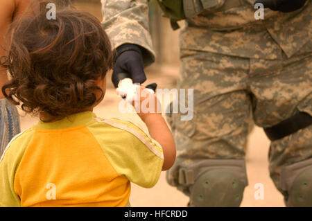Un iracheno bambino raggiunge fuori per ricevere un puffo da U.S. Soldato. Iracheno di polizia nazionali e degli Stati Uniti Soldati dal 64th Armored reggimento di cavalleria, quarta brigata, terza divisione di fanteria ha cercato una mullalah in Risalah, a Baghdad il 7 settembre 15, 2008, al fine di documentare i militari locali in età maschi residenti lì. Polizia, militari visita i civili iracheni 116297 Foto Stock