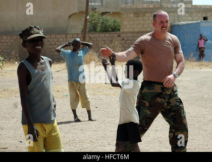 Un organo di servizio da parte degli Stati Uniti Ambasciata a Dakar, Senegal, dà una alta cinque a un ragazzo senegalese mentre si gioca a calcio al Vivre Ensemble orfanotrofio dopo un team di Africa Partnership Station 2009 membri consegnati donato forniture scolastiche dal progetto Handclasp. I membri del servizio lavora con Africa Partnership Station consegnati donato forniture scolastiche dal progetto Handclasp alla scuola. Africa Partnership Station è un'iniziativa internazionale sviluppato da forze navali in Europa e forze navali in Africa, che mira a lavorare con gli Stati Uniti e i suoi partner internazionali al fine di migliorare la sicurezza marittima e securi Foto Stock