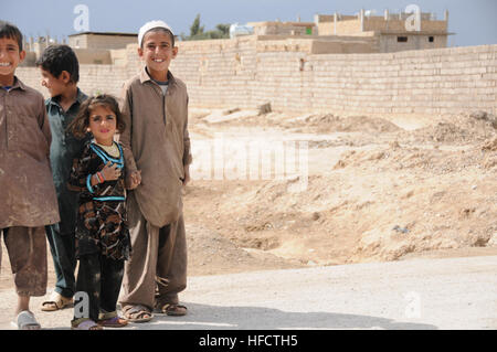 Giovani bambini Farahi posano per una foto al di fuori del sito di una chiave del leader hanno partecipato di impegno da parte dei membri del team dal Provincial Reconstruction Team (PRT) Farah nella città di Farah, Feb. 25. Civili e Militari di rappresentanti del PRT ha visitato di recente costruzione di Orientamento Familiare Center gestito da afghani azionato a voce delle ONG delle donne nella città di Farah per discutere le questioni di genere, condurre un sondaggio del sito e monitorare la programmazione. PRT Farah ha la missione di treno, consigliare e assistere il governo afgano leader a livello comunale, distretto e i livelli provinciali nella provincia di Farah, Afghanistan. Il civile milit Foto Stock