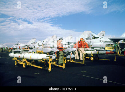 Un aviation ordnanceman ispeziona un ADM-141 Tactical air-lanciato decoy come i suoi compagni di lavoro AGM-88un danno ad alta velocità a anti-missili di radiazione sul ponte di volo della USS John F. Kennedy (CV-67). Piani a bordo del Kenedy vengono montati per gli scioperi su obiettivi iracheni all'inizio dell'operazione tempesta del deserto. ADM-141 TALD a bordo della USS Kennedy Foto Stock