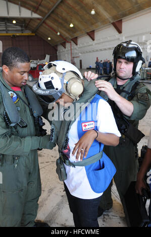 GUANTANAMO Bay a Cuba - AWS2 (NAC/AW) Stephen Brant, un capo equipaggio con elicottero contromisura Mine Squadron 14 fa un ultimo controllo di preflight di ingranaggio di sicurezza per Diana San Louis, un americano il volontario della Croce Rossa da New York prima di salire a bordo di un MH-35E mare Dragon elicottero legato per Haiti a U.S. Stazione navale di Guantánamo Bay airfield, 22 gennaio 2010. I membri del servizio dalla Marina Militare Elicottero della miniera contromisure Squadron 14 e 15, distribuiti a supporto di funzionamento risposta unitaria, sono adibiti al trasporto di personale e materiali di consumo per assistere le vittime del gen. 12, 2010 Terremoto ad Haiti. (JTF Guantana Foto Stock