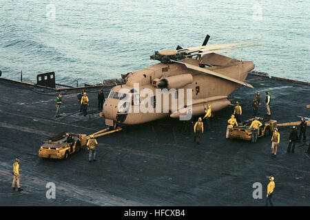 A trainare il trattore si muove un RH-53 Sea Stallion elicottero in posizione sul ponte di volo dell'energia nucleare portaerei USS NIMITZ (CVN-68) prima di iniziare la procedura di funzionamento della luce della sera, una missione di soccorso per l'Iran. RH-53D su ascensore di USS Nimitz (CVN-68) off Iran 1980 Foto Stock