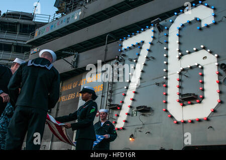 YOKOSUKA, Giappone (dec. n. 02, 2016) marinai ritiro nazionale di alfiere in serata durante i colori sul ponte di volo dell'U.S. La marina è solo distribuita portaerei USS Ronald Reagan (CVN 76), dopo aver completato un programma tre mesi di pattugliamento nell Indo-Asia-regione del Pacifico. Durante la pattuglia, Ronald Reagan ha partecipato a esercitazioni Valiant scudo, invincibile spirito e appassionato di spada, progettato per migliorare le operazioni militari congiunte con i paesi partner in tutta la regione. L'equipaggio anche completato il suo livello unità Assessment-Sustainment per la formazione e la manutenzione e la gestione del materiale di valutazione. Ro Foto Stock