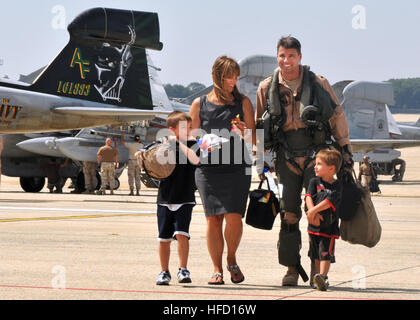 La Cmdr. Michael Esper, assegnato alla stella guerrieri di Attacco Elettronico Squadron 209, lascia la linea di volo con sua moglie e i suoi due figli durante una celebrazione homecoming a base comune Andrews Naval Air Facility. VAQ-209 completato un periodo di tre mesi, distribuita tour in Afghanistan sostenendo l Operazione Enduring Freedom. I marinai di ritorno a casa 316546 Foto Stock