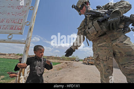 Una coalizione di forze per le operazioni speciali soldato dà una penna per un giovane bambino nel Villaggio Sanawghan, provincia di Herat, Afghanistan, Aprile 8. Afghan Polizia Locale Leader e la coalizione di SOF ha visitato il villaggio di condurre una shura con gli anziani del villaggio per discutere la futura espansione di ALP. (U.S. Foto di Marina di Massa lo specialista di comunicazione 1a classe Jeffery Tilghman Williams / rilasciato) Sanawghan village shura 120409-N-WX845-204 Foto Stock