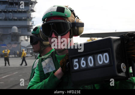 Petty Officer di terza classe Doug Bellew visualizza il peso di un F/A-18F Super Hornet della catapulta il responsabile della sicurezza prima di prendere il largo sul ponte di volo della centrale nucleare-powered portaerei USS Nimitz. Nimitz e Carrier aria Wing 11 sono adattate di conduzione della nave la disponibilità di formazione al largo della costa della California del Sud. Azione dell'antenna a bordo della USS Nimitz 154443 Foto Stock