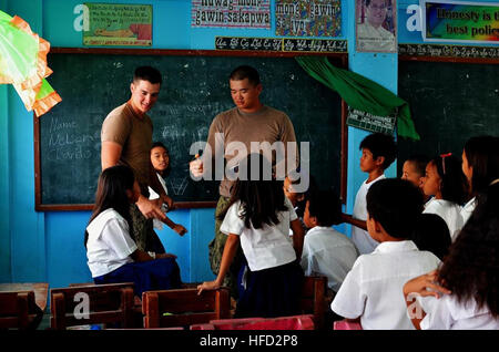 PALAWAN, Filippine (feb. 5, 2013) Builder di terza classe Shortridge Brandon e Builder Constructionman Danny Nguyen, entrambi assegnati alla Naval Mobile Battaglione di costruzione (NMCB) 5, premiare il vincitore di un concorso di matematica con un lecca-lecca. Shortridge sostituisce temporaneamente come un insegnante di matematica per 4 grado di studenti Aplaya scuola elementare. Il NMCB 5 Costruzione attività civica dettaglio (CCAD) Filippine è la costruzione di un due-classroom edificio in muratura per la scuola. Seabees condurre operazioni CCAD come questo al fine di dimostrare il proprio impegno USA, sviluppare rapporti duraturi, migliorare Foto Stock