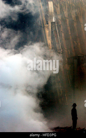 010914-N-1350W-004 New York, N.Y. (Sett. 14, 2001) -- Un solitario fire fighter sorge tra le macerie e fumo in New York City. Giorni dopo una sett. 11 attacco terroristico, incendi ancora bruciano presso il sito del World Trade Center. Stati Uniti Navy foto dal fotografo di Mate 2a classe Jim Watson. (Rilasciato) Settembre 14 2001 Ground Zero 02 Foto Stock