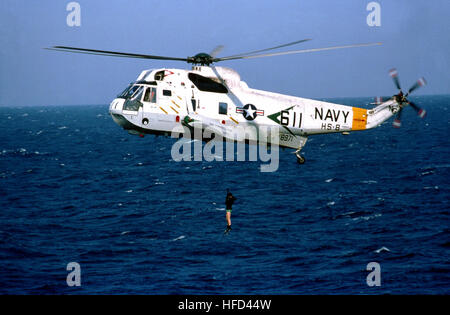 Vista laterale sinistra di una SH-3un mare re elicottero dimostrando di procedure di salvataggio durante il Segretario della Difesa Caspar Weinberger la visita della portaerei USS Constellation (CV 64). L'elicottero è da elicottero anti-sommergibile Squadron 8 (HS-8). SH-3H Sea King HS-8 con subacqueo 1982 Foto Stock