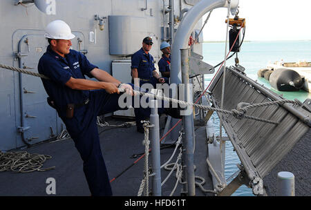 Stati Uniti Marina di Boatswain mate 1. Classe Dmitry Spiridonov, foreground, fissa un alloggio scala sul lato della porta di missile fregata USS Underwood (FFG 36) come la nave si allontana U.S. Stazione navale di Guantánamo Bay, Cuba, luglio 19, 2012. Underwood è stata distribuita in America centrale e del Sud e nei Caraibi a sostegno dei Mari del Sud 2012. I mari del sud è un U.S. Comando sud-diretto operazione destinata a rafforzare le relazioni con partner regionali delle nazioni e migliorare la disponibilità operativa per tutte le unità assegnate. (U.S. Foto di Marina di Massa lo specialista di comunicazione di terza classe Frank J. Foto Stock