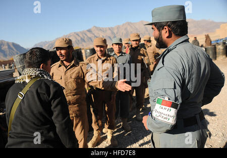 Afghan Polizia locale linea istruttori fino ai candidati di verificare per vivere le munizioni prima di ricevere la loro paga mensile nel distretto di Gizab, provincia di Uruzgan, nov. 30. ALP candidati andare attraverso tre settimane di corso di formazione per imparare il funzionamento di base il maneggiamento delle armi, esplosivi improvvisati consapevolezza del dispositivo e movimenti Patrol. Afghan Polizia locale il giorno di paga- VET-CAP 111130-N-UD522-011 Foto Stock