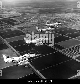 Un aria-aria - Vista laterale destra di quattro Training Squadron 21 (VT-21) TA-4J Skyhawk aeromobili battenti in formazione durante uno sciopero addestramento alle armi volo su Naval Air Facility, El Centro. TA-4Js VT-21 vicino NAF El Centro 1986 Foto Stock