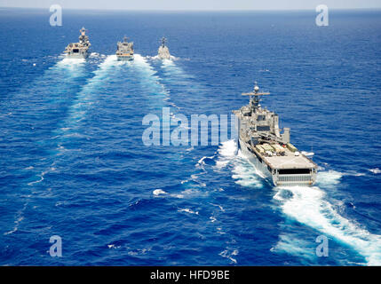 Il dock di anfibio sbarco nave USS Rushmore (LSD 47), primo piano, vi attende per rendere il suo approccio durante l'assalto anfibio nave USS Peleliu (LHA 5), a sinistra e il missile destroyer USS Spruance (DDG 111), destra, condotta a una ricostituzione in mare con il combattimento veloce nave appoggio USNS Ranieri (T-AOE 7) nell'Oceano Pacifico il 24 giugno 2014. Le navi erano in rotta per partecipare al bordo del pacifico esercizio 2014, U.S. Flotta del pacifico-hosted multinazionale biennale esercizio marittimo progettato per promuovere e sostenere la cooperazione internazionale sulla sicurezza del mondo?s oceani. (U.S. Navy Foto Stock