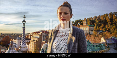 Firma di Barcellona style. elegante viaggiatore la donna a ricoprire a Parco Guell a Barcellona Spagna guardando in lontananza Foto Stock