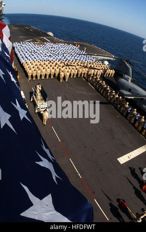 011218-N-2383B-515 in mare a bordo della USS Bataan (LHD 5) Dec.18, 2001-- marinai e marines della USS Bataan Anfibio del gruppo pronto rendere onore a stelle e strisce battenti alto sopra il comando anfibio della nave. Il Bataan conduce una speciale cerimonia di bandiera per la prima bandiera a "Ground Zero' World Trade Center. La famosa bandiera è stata sollevata nel mezzo di macerie da New York City vigili del fuoco e da allora è stato portato dalla U.S. Navy navi che operano a sostegno dell'Operazione Enduring Freedom. Stati Uniti Navy Foto di Chief Fotografo compagno del Johnny Bivera. (Rilasciato) Navy US 011218-N-2383B-5 Foto Stock