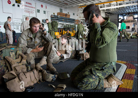 Royal New Zealand army Pvt. Jared Walch (sinistra), assegnata al 1° Royal New Zealand Reggimento di Fanteria (1RNZIR), e Cpl. Sarà Salikin, assegnati al 3° Battaglione Princess Patricia canadese della fanteria leggera (3PPCLI), prova le loro radio portatili nell'hangar bay dell'assalto anfibio nave USS Peleliu (LHA 5) prima di un esercizio di formazione durante il cerchio del Pacifico (RIMPAC) Esercizio 2014. Ventidue nazioni, 49 navi e sei sommergibili, più di 200 aerei e 25.000 personale partecipano RIMPAC dal 26 giugno al 1 agosto in e intorno alle Isole Hawaii e la California del Sud. Th Foto Stock