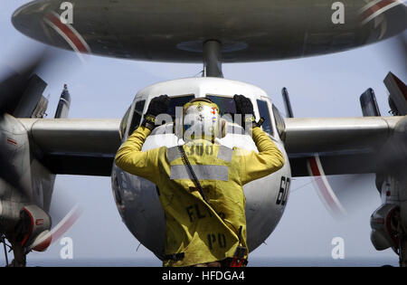 020313-N-9769P-005 in mare a bordo della USS John C. Stennis (CVN 74) Mar. 13, 2002 -- Aviazione di Boatswain Mate 3° di classe Alejandro Contreras da Los Angeles, CA, attentamente dirige un E-2C 'Hawkeye' sulla nave del ponte di volo, mantenendo le eliche di filatura chiaro delle attrezzature e del personale. Il E-2C aeromobile è assegnato al 'Golden Hawks' di Carrier Airborne Early Warning Squadron uno uno due (VAW-112) avviato con Carrier aria Wing nove (CVW-9) a bordo John C. Stennis condurre missioni di combattimento a sostegno dell'Operazione Enduring Freedom. Stati Uniti Navy foto dal fotografo compagno del 3° di classe Jayme passato Foto Stock