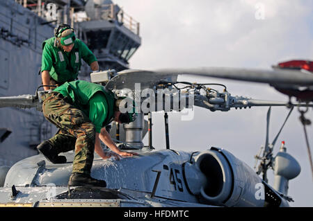 Stati Uniti 5TH FLOTTA AREA DI RESPONSABILITÀ (dec. n. 2, 2012) - Aviazione macchinista compagno del 3° di classe Nathan Morris e aviazione da elettricista, Mate Airman Jason Robertson scrub off sale di mare da un MH-60S Knighthawk elicottero, assegnato al "wild card" di elicottero da combattimento Squadron 23 a bordo di assalto anfibio nave USS Peleliu (LHA 5). Peleliu è il fiore all' occhiello di Peleliu anfibio gruppo pronto e insieme con la avviato xv Marine Expeditionary Unit sono distribuiti nel supporto del le operazioni di sicurezza marittima e di teatro la cooperazione in materia di sicurezza gli sforzi negli Stati Uniti Quinta Flotta area di responsabilità. (U.S Foto Stock