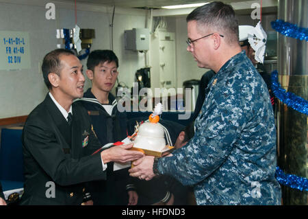 151218-N-RU971-412 Sasebo, Giappone (dec. n. 18, 2015) - Japan Maritime Self Defence Force (JMSDF) Capo Hirosahi Nishitani, da Shirane-class destroyer JDS Kurama (DDH 144), presenta una tradizionale torta di riso al Master Chief aviazione di Boatswain Mate Frank Bartanowitz nel capo il pasticcio a bordo distribuita Amphibious Assault nave USS Bonhomme Richard (LHD 6). Bonhomme Richard è la nave di piombo del Bonhomme Richard anfibio gruppo pronto e viene distribuita a Sasebo, Giappone negli Stati Uniti 7 flotta area di operazioni. (U.S. Foto di Marina di Massa lo specialista di comunicazione di terza classe Cameron McC Foto Stock