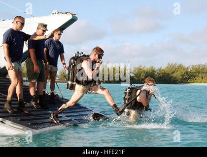 040709-N-0000H-001 Diego Garcia (Luglio 9, 2004) Ð U.S. Navy Seabees, Constructionman 1a classe James Richardson passi in acqua un passo dietro il compagno di subacqueo Constructionman 1a classe Steven Hentze all'inizio di un immersione pianificato. Richardson e Hentze e altri membri della costruzione subacquea Team due (UCT-2) sono in Diego Garcia Territori britannici dell'Oceano Indiano (BIOT), per eseguire interventi di manutenzione sul molo strutture. Costruzione subacquea team a offrire una capacità di costruzione, ispezione, riparazione e manutenzione di ocean strutture di sostegno navali e Marine Corps operations, incl Foto Stock