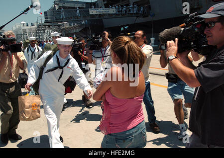 040723-N-9288T-279 San Diego California (Luglio 23, 2004) - Un marinaio saluta il suo amato dopo la partenza di USS Ronald Reagan (CVN 76). Il NavyÕs più nuovi e tecnologicamente più avanzato per la portaerei è il completamento di due mesi di transito da Norfolk, Virginia Homeporting celebrazioni includevano vari dignitari come ex First Lady Nancy Reagan, membri del Congresso, di funzionari statali e celebrità. La nave, comandato da Capt. James A. Symonds, è stato commissionato nel luglio 2003. Stati Uniti Navy foto di PhotographerÕs Mate 2a classe Brandon Teeples (rilasciato) Navy US 040723-N-9288T-279 un marinaio saluta il suo amato a poppa Foto Stock