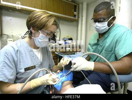 040812-N-2541H-001 Golfo Arabico (Agosto 12, 2004) Ð Navy dentista Lt. Jennifer Ellis e odontotecnico Seaman Richard Tate eseguire una routine estrazione del dente a bordo della portaerei USS John F Kennedy (CV 67). Kennedy e Carrier aria Wing diciassette (CVW-17) sono operanti nella regione del Medio Oriente come parte dell'Operazione Iraqi Freedom. (OIF) Unità nel vettore Kennedy Strike gruppo (CSG) stanno lavorando a stretto contatto con Corps-Iraq multinazionali e le forze irachene a portare stabilità al governo sovrano dell'Iraq. Stati Uniti Navy foto di PhotographerÕs Mate 3° di classe William Hiembuch (rilasciato) Noi Na Foto Stock