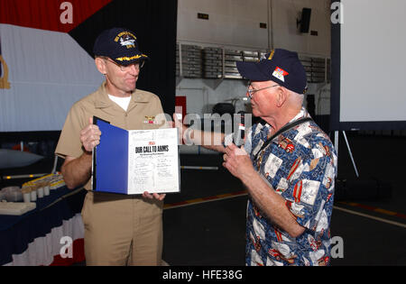 040811-N-4776G-070 San Diego, California (Agosto 11, 2004) - USS Ronald Reagan CVN (76) comandante, cap. James Symonds, è presentato con una seconda guerra mondiale (WWII) prenota autografati da Pearl Harbor superstiti e presentato dal sig. Jessie Tompson, durante una visita alla portaerei. L'energia nucleare nave arrivò nel suo nuovo homeport della Naval Air Station North Island, San Diego, dopo la partecipazione ad esercitazioni a supporto di impulso di estate 2004. Stati Uniti Navy foto dal fotografo di Mate Airman Kathleen Gorby (rilasciato) Navy US 040811-N-4776G-070 USS Ronald Reagan CVN (76) comandante, cap. Foto Stock