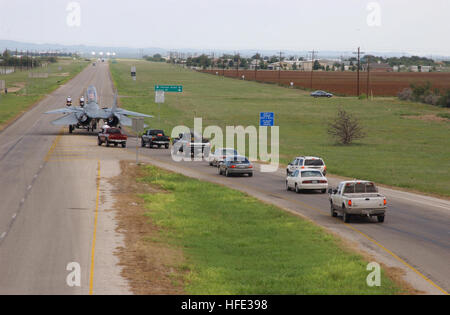 Una linea di moduli di traffico dietro un F-14A Tomcat come esso viene trasportato il 19,5 miglia da San Angelo aeroporto regionale di Goodfellow Air Force Base in Texas ad una velocità di 5 MPH dopo essere stata smantellata dalla Marina Militare. Ogni paio di miglia di auto sarebbe diretto da San Angelo del dipartimento di polizia di scorta per aiutare ad alleviare il traffico costruire. Questo F-14A è stato il primo F-14A essere smantellata dalla Marina militare ed è stato acquistato da Goodfellow AFB per $20.000 per essere utilizzati per la formazione mediante la 312Training Squadron incendio dell Accademia di formazione. Il piano dei motori, armi e relativi sistemi dovevano essere rimossi prima di Foto Stock