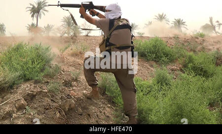 Ancora immagine presa da un ISIS propaganda video che mostra lo stato islamico militanti sparando AK-47 fucili automatici durante le battaglie in Iraq 15 giugno 2016 vicino a Fallujah in Iraq. Foto Stock