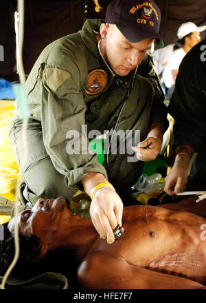 050103-N-4166B-473 Aceh e Sumatra, Indonesia (GEN. 3, 2005) - USA Navy Corpsman ospedale di terza classe Casey Wheller dà attenzione medica per un infortunio per un uomo indonesiano dopo essere stata medicalmente evacuati da un villaggio costiero sull isola di Sumatra, Indonesia. Le équipe mediche da USS Abraham Lincoln (CVN 72), Carrier aria Wing due (CVW-2) e l'Organizzazione internazionale per la migrazione (IOM) impostare fino ad un sito di triage situato sulla Sultan Iskandar Muda Air Force Base, a Banda Aceh e Sumatra. Le due squadre hanno lavorato insieme con i membri della Australian Air Force per fornire le prime cure mediche alle vittime di Foto Stock