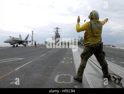 021209-N-6895M-503 in mare a bordo della USS Theodore Roosevelt CVN (71) Dic. 9, 2002) -- un piano direttore guida una F/A-18 ÒHornetÓ dal ÒHuntersÓ di Strike Fighter Squadron due zero uno (VFA-201) in posizione sulla shipÕs ponte di volo. VFA-201 è parte di Carrier aria Wing otto (CVW-8) imbarcato a bordo di Theodore Roosevelt. Stati Uniti Navy foto di PhotographerÕs Mate 2a classe James K. McNeil. (Rilasciato) Navy US 021209-N-6895M-503 piano direttore guide un F-A-18 in posizione sulla nave%%5Ersquo,s ponte di volo Foto Stock