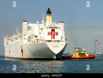 050608-N-9500T-009 San Diego, California (8 giugno 2005) - un rimorchiatore che assistono i militari Sealift Command (MSC) nave ospedale USNS misericordia (T-AH 19) Come si prepara per ormeggiare alla stazione navale di San Diego. La misericordia è di ritorno da cinque mesi di distribuzione nel supporto di tsunami e aide umanitario delle missioni in vari Southeast Asia nazioni. Stati Uniti Navy foto dal fotografo di Mate 2a classe Scott Taylor (rilasciato) Navy US 050608-N-9500T-009 una chiatta battenti bandiera americana vele dai militari Sealift Command (MSC) nave ospedale USNS misericordia (T-AH 19) si prepara a moor Foto Stock