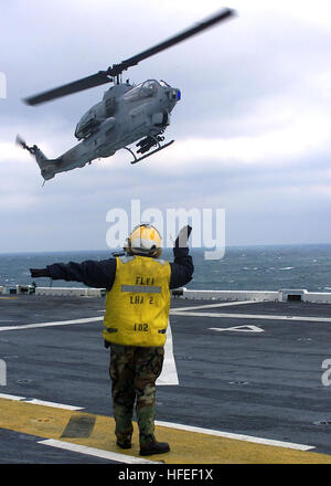 030117-N-9109V-004 in mare a bordo della USS Saipan (LHA-2) Gen 17, 2003 -- Avaiation BoatswainÕs Mate 3° di classe Jennifer Rohrbaugh da Pittsburgh, Pa., segnali un AH-1W ÒSuper CobraÓ elicottero assegnato al Marine gruppo aria 29, imbarcato a bordo dell'assalto anfibio della nave. Saipan sta attualmente conducendo esercizi con i suoi anfibi gruppo pronto. Stati Uniti Navy foto di PhotographerÕs Mate Airman Kyle T. Voigt. (Rilasciato) Navy US 030117-N-9109V-004 un AH-1W Super Cobra terre a bordo di una nave Foto Stock